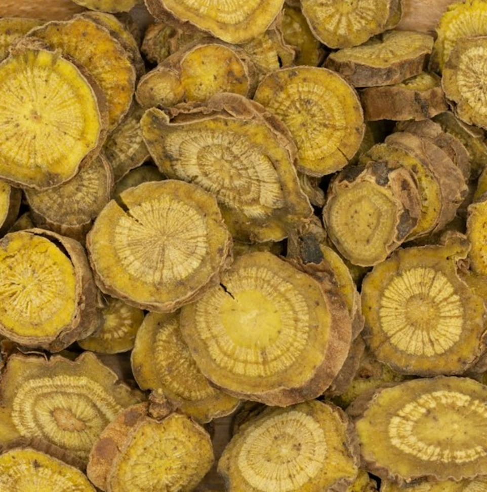 a wooden bowl filled with green vegetables on top of a white table